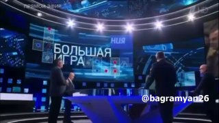 Александр Ионов в зеленом на фоне российского телеканала